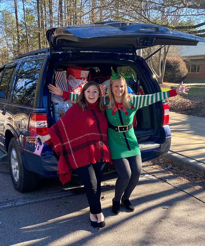 Sydney Hardy and Erin Creech delivering gifts to the school