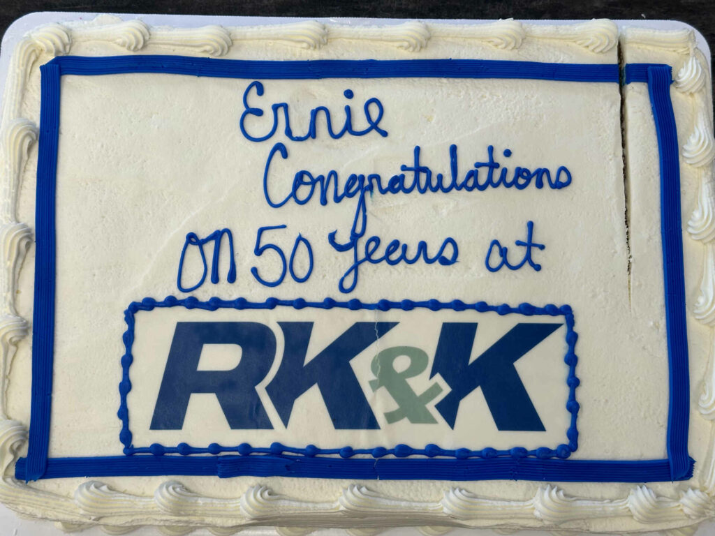 a white cake with blue lettering with the words "Ernie congratulations on 50 years at RK&K"