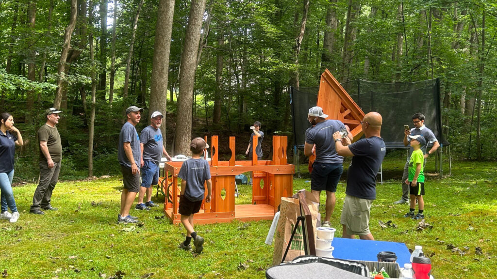 A group building the tower of the playset