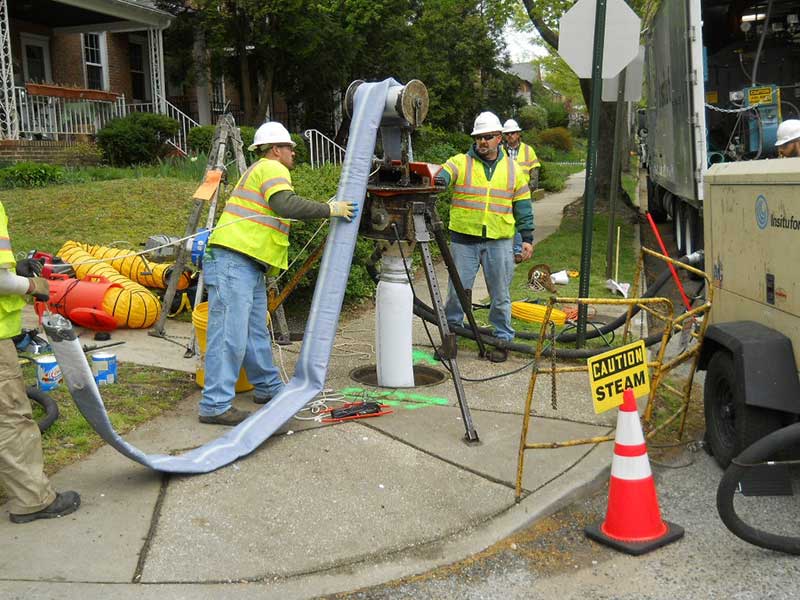 Construction workers on a sidewalk.